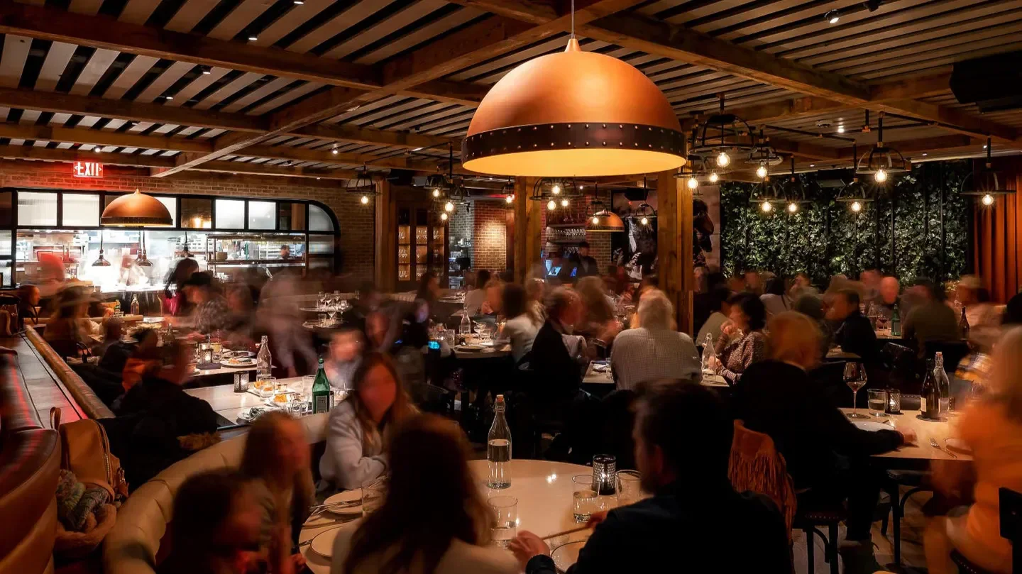 Busy dining room at Catch Steak Aspen, with cozy lighting and bustling atmosphere in Aspen