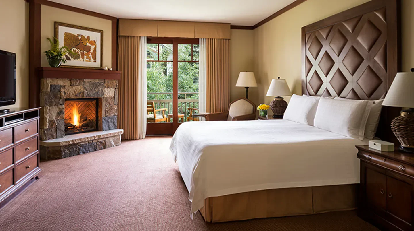 Cozy bedroom at Four Seasons Resort and Residences Vail in Aspen, with fireplace and balcony.