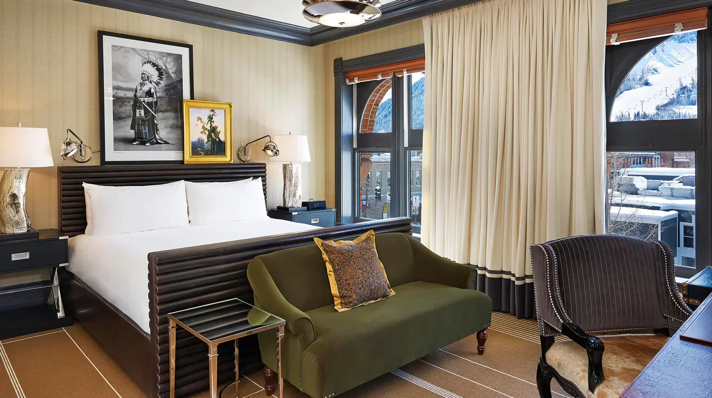 Cozy bedroom at Hotel Jerome, Auberge Resorts Collection in Aspen, with mountain view.
