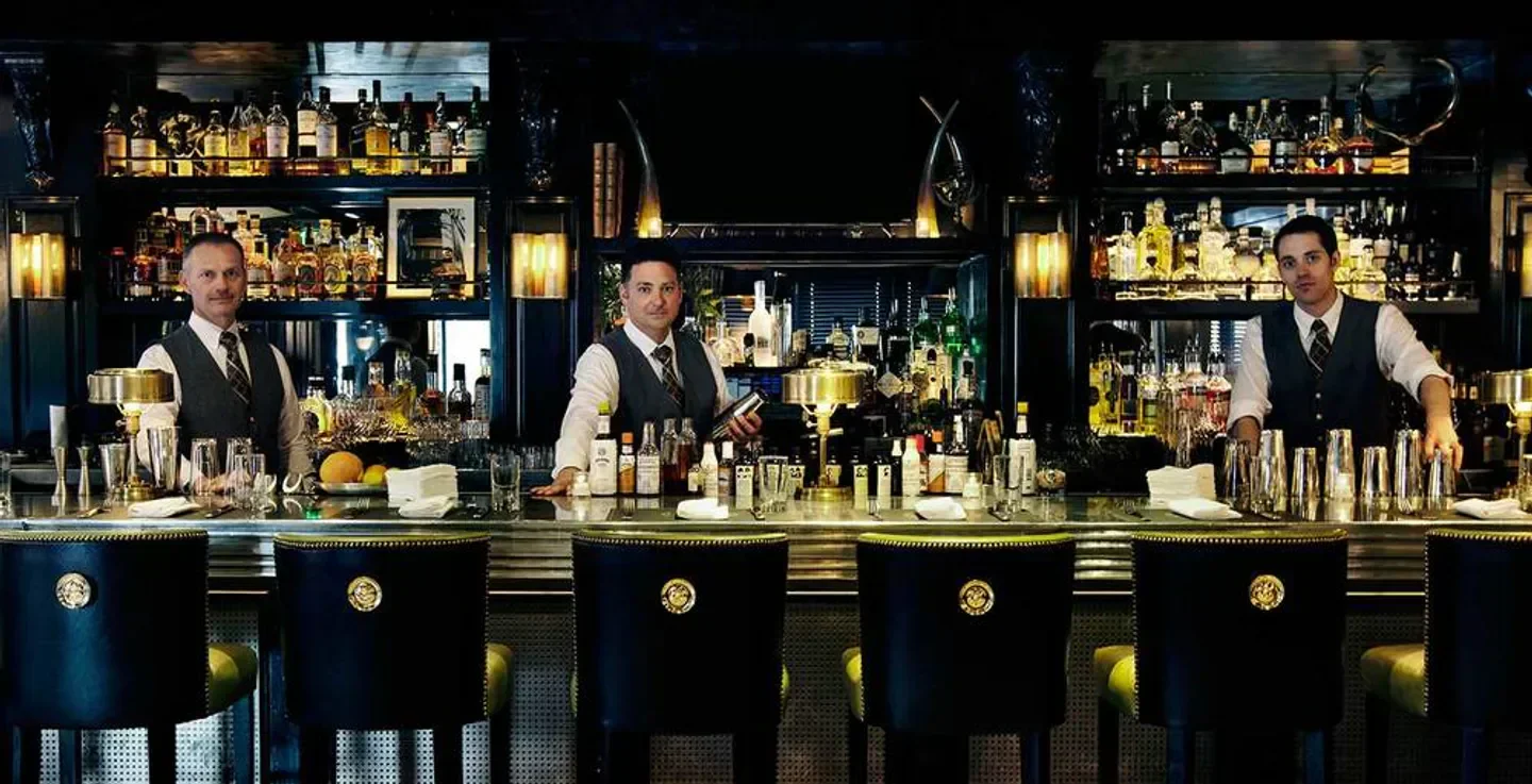 Classic bar at The Monarch in Aspen with bartenders and a well-stocked liquor display.