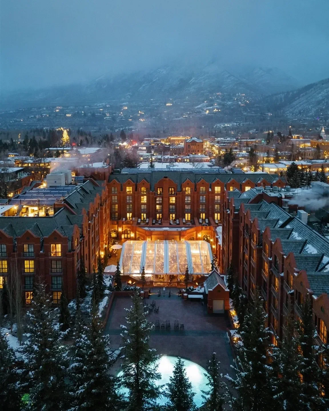 Velvet Buck restaurant in Aspen at dusk, illuminated with a mountain backdrop